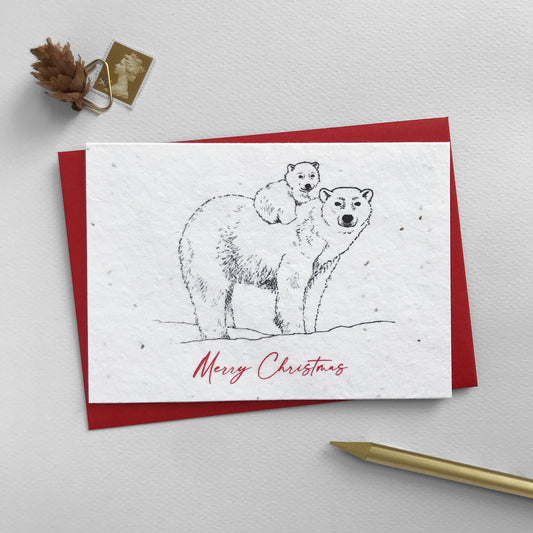 Image shows a Bloom Cards A6 plantable Winter Animals Christmas card featuring a baby polar bear riding on it's mother's back. The red script style text underneath reads 'Merry Christmas'. This eco-friendly, biodegradable card is made from recycled cotton embedded with bee friendly wildflower seeds, so when the festivities are over, it can be planted to grow beautiful flowers for the garden. Each card comes with a recycled red envelope.