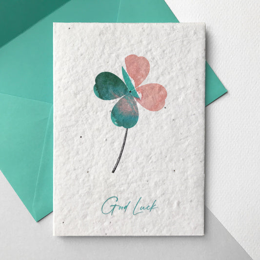Image of Bloom Cards A6 plantable good luck card featuring a hand illustrated four leaf clover design. Watercolour washes in coral and mint are used to create colourful leaves, with a pen drawn stem detail. The recycled cotton card is available printed onto wildflower seed paper, so your recipient can grow their card and enjoy watching beautiful their bee friendly flowers bloom. The card comes with a matching mint fsc certified eucalyptus envelope.
